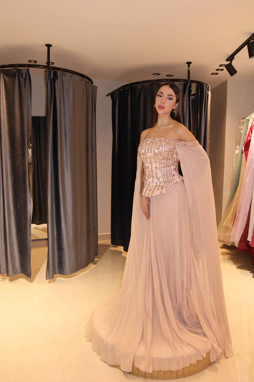 Blush-Nude Pleated Chiffon Gown with Jeweled Corset and Dramatic Cape Sleeves